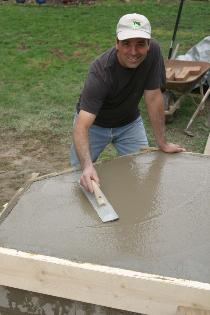 Jeff Wilson smoothing concrete for a DIY Brick Bread Oven