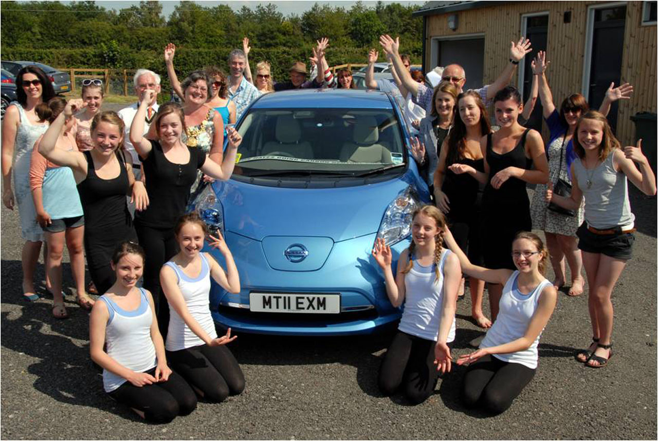 Student eco volunteers around the Nissan Leaf