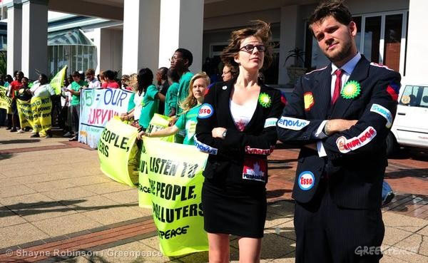 Greenpeace activists protest the influence of carbon-intensive industry over the negotiating governments.