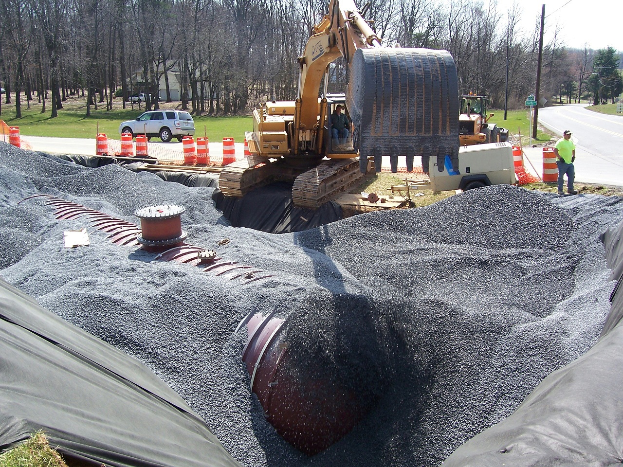 infilling the hole with gravel after placing an underground water tank