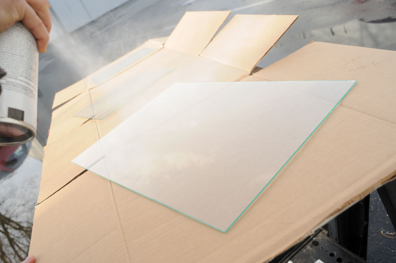 Spraying primer on the glass for a DIY framed chalkboard