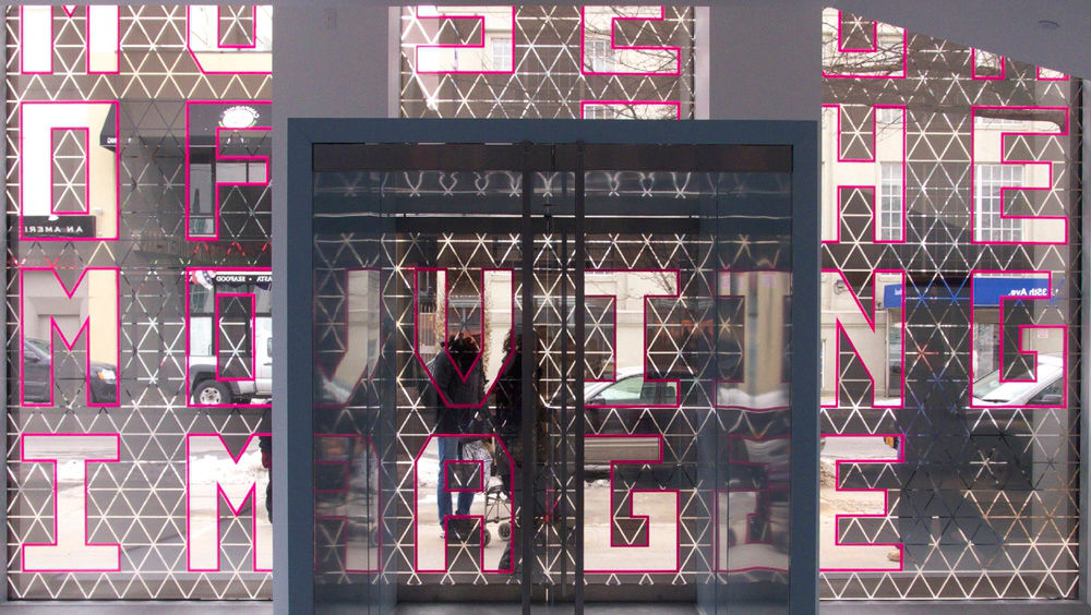 The entrance of New York City's Museum of the Moving Image designed by Leeser Architecture made up of tall hot pink letters.