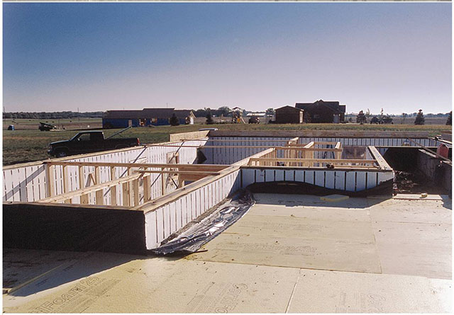 Employees from Bill Eich Construction install ridged foam insulation for a garage slab.