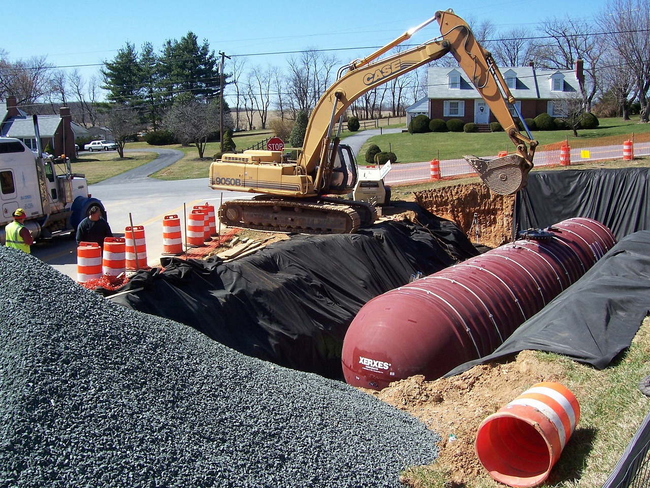 lowering an underground water tank with a backhoe