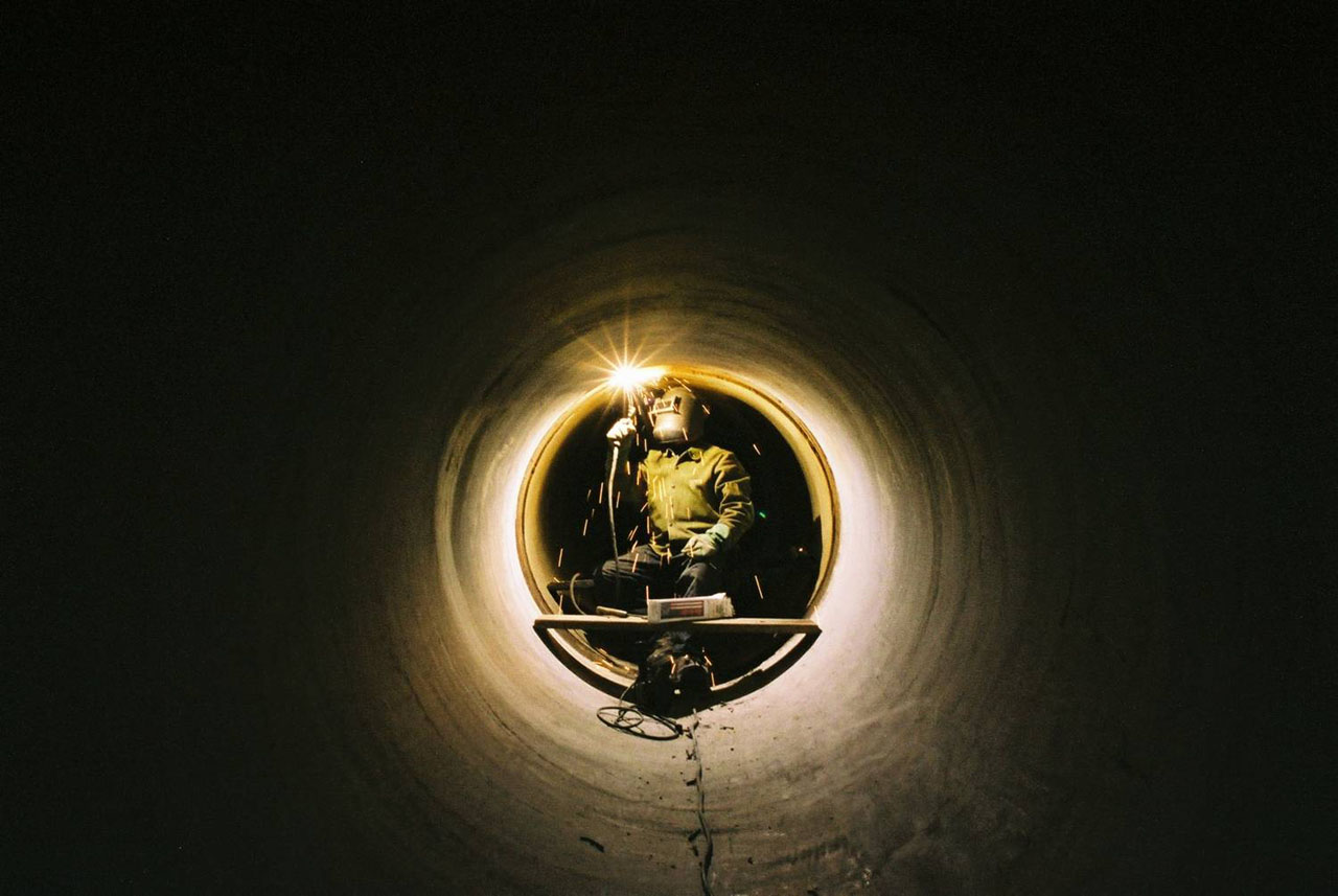 Welder inside a pipe used for Toronto's Deep Lake Water Cooling System